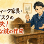 アンティークの木製デスクを調べながらレトロな鍵を持つ、正直な鍵屋たこやきのイラスト。画像内に「アンティーク家具・古いデスクの鍵紛失！特殊な鍵の作成」と文字が入っている